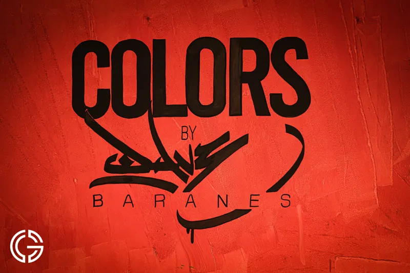 L'enseigne noire « Colors » peinte sur un mur rouge.