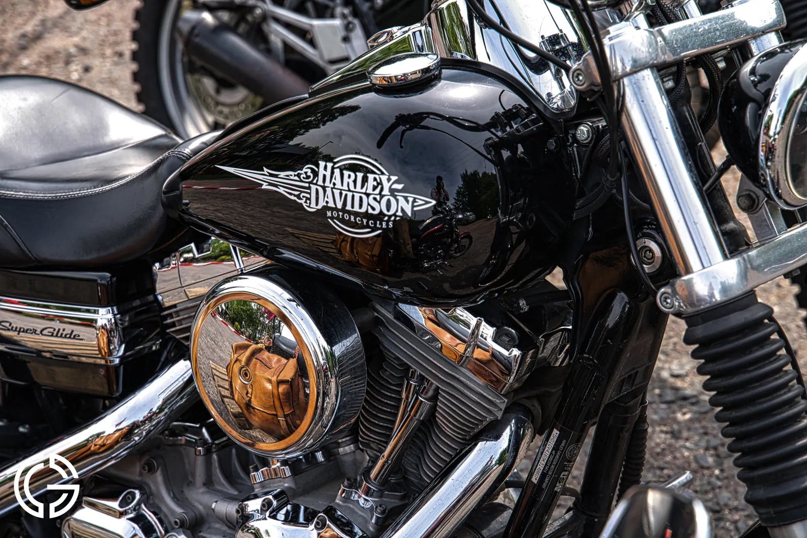 Gros plan sur le réservoir noir et chromé d'une Harley-Davidson.